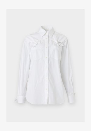 White long-sleeve button-up shirt with collar and two chest pockets, each featuring a decorative bow near the top.