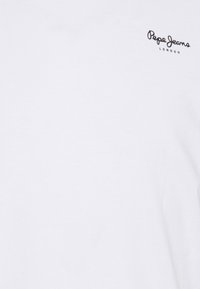 Weißes Baumwoll-T-Shirt mit kleinem schwarzem "Pepe Jeans London"-Logo auf der linken Brustseite. Glatte Textur, kurze Ärmel und Rundhalsausschnitt.