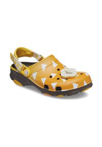 Yellow clogs featuring a triangular pattern in white, a tan circular accent on the front, and a brown sole with ventilation holes.