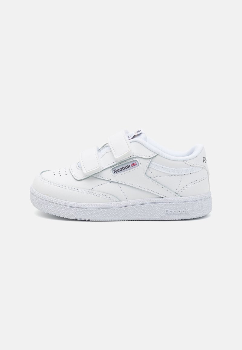 Baskets en cuir blanc avec deux bandes velcro, boîte à orteils perforée, col rembourré et semelle en caoutchouc texturé avec le logo Reebok.