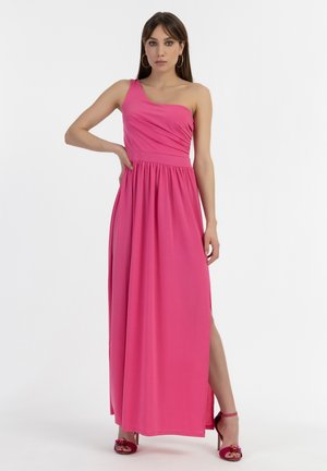 Fuchsia Maxikleid mit einem Schulterträger, gerafftem Oberteil, fließendem Rock, seitlichem Schlitz und weichem Stoff. Kombiniert mit pinken Absatzsandalen.