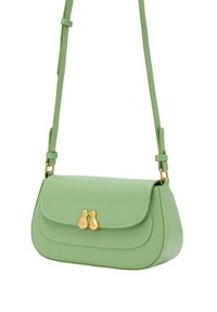 Grön faux läder crossbody-väska med en böjd form, guldhardware-lås och justerbar rem. Har kontrasterande sömmar som detalj.