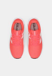 Bright coral New Balance running shoes with white "N" logo, laces tied, viewed from above on a white background.