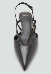 Musta patenttinojalla slingback-kengät, joissa on terävä nenä, ohut säädettävä remmi ja minimaaliset tikkausyksityiskohdat. Kulta logo sisäpohjassa.