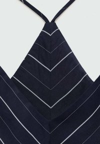 Námořnická tkanina s chevron vzorem a tenkými bílými pruhy. Popruhy se spojují v zadní části a vytvářejí tvar písmene V. Je viditelný strukturovaný povrch.