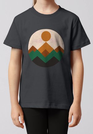 Kind trägt ein dunkelgraues T-Shirt mit einem kreisförmigen Design aus geschichteten braunen und grünen Bergen und einer orangefarbenen Sonne auf der Brust.