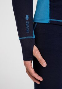 Langærmet thermotrøje i marineblå og blå, med tommelhuller, ribbet tekstur og "DOVRE" broderet logo på venstre ærme.