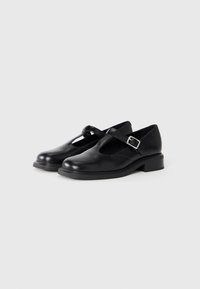 Black leather Mary Jane shoes with a round toe, buckle strap, and low block heel. Smooth texture with minimal detailing.