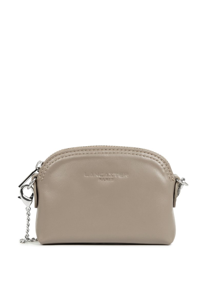 Portamonete in pelle beige con cima curvata, zip argentata e catena. Presenta il marchio "Lancaster Paris" in rilievo sul frontale.