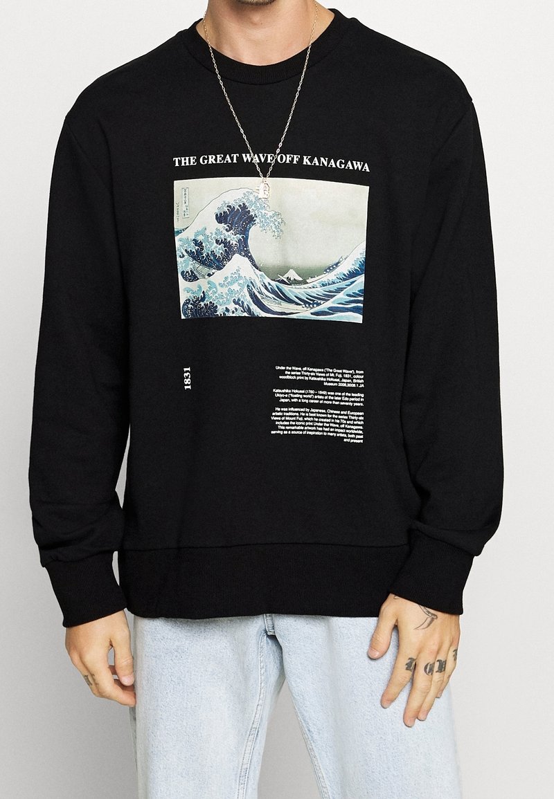 Sudadera negra con un gráfico frontal de "La Gran Ola de Kanagawa" y texto debajo. Tela suave, ajuste relajado, puños y dobladillo acanalados.
