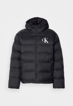 Una chaqueta acolchada negra con cremallera frontal, capucha y el logo "CK" en blanco. Presenta un diseño acolchado y una textura suave y brillante.