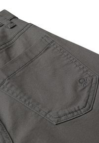 Šedé látkové kalhoty s zadní kapsou, jemným šitím, malým logem a hladkým povrchem.