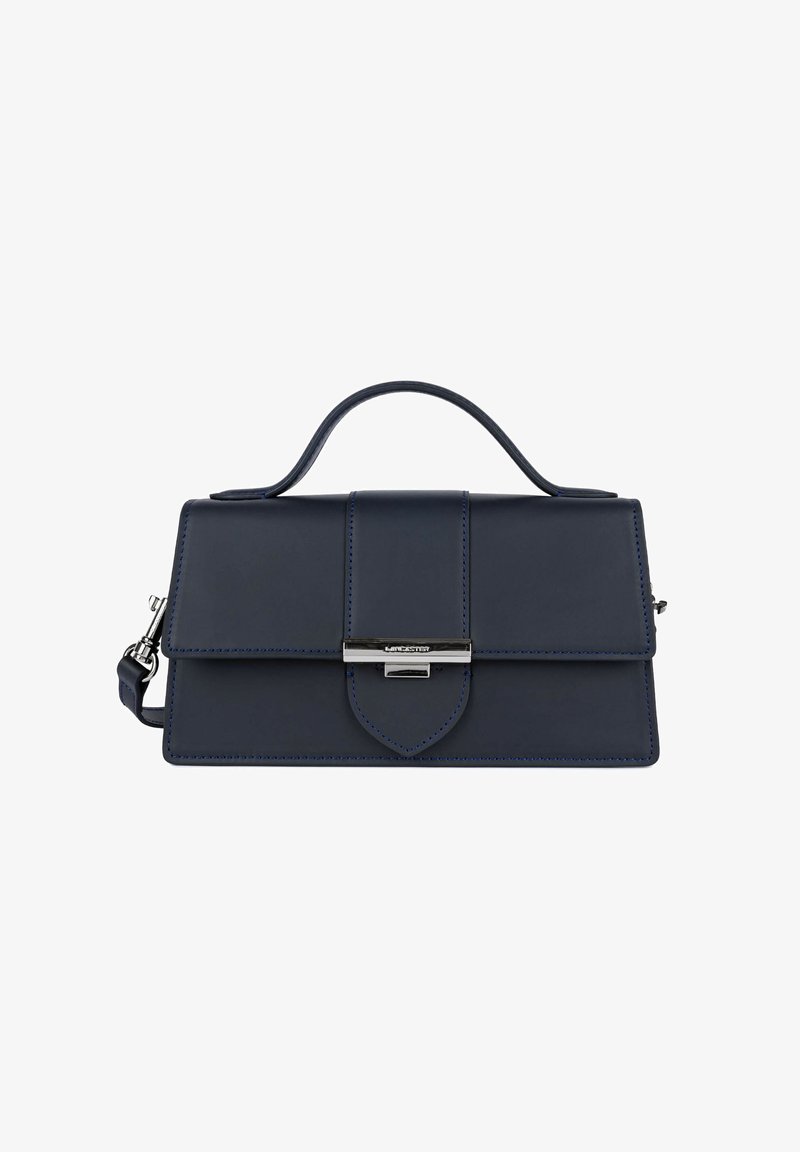 Sac à main en cuir bleu marine avec poignée supérieure, fermeture à rabat, boucle ton argent et bandoulière amovible sur fond blanc.