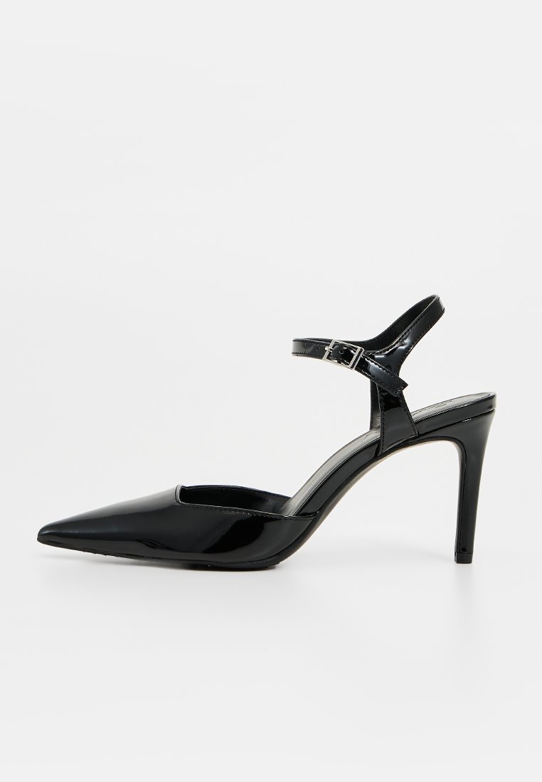 Scarpa con tacco alto in vernice nera, punta affusolata, con cinturino alla caviglia e fibbia, caratterizzata da un design elegante e una finitura lucida.