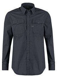 Camicia a maniche lunghe blu scuro in cotone, con due tasche sul petto, polsini con bottoni e orlo arrotondato; texture liscia con branding minimo.