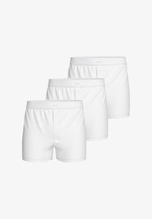 Zestaw trzech białych slipów boxer wykonanych z gładkiego materiału, z guzikiem w kroku, elastycznym paskiem i czystym, prostym wzorem.