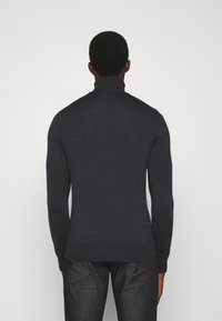 Pull à col roulé bleu marine avec manches longues, col et ourlet côtelés, fabriqué en matière tricotée, présentant une silhouette cintrée.