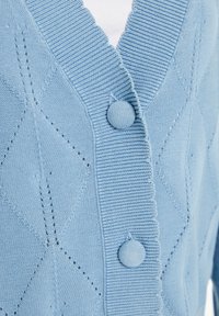 Pletený modrý kardigan se strukturální diamantovou vzorováním, žebrovaným límcem a dvěma kulatými knoflíky vpředu.