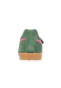 Sneaker verde in suede con strisce laterali rosa, suola in gomma beige, tacco arrotondato e motivo a zigzag sulla suola. Vista dalla parte posteriore.