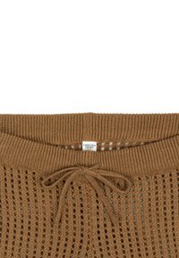 Pull en tricot brun avec un motif en dentelle, doté d'un cordon de serrage au niveau du cou et d'une étiquette indiquant "CHELSEA PEERS."