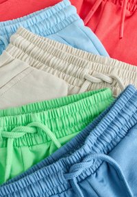 Stos pięciu złożonych elastycznych pasów z sznurkami w kolorach koralowym, jasnoniebieskim, beżowym, zielonym i niebieskim.