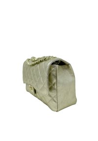 Pikowana torebka w metalicznym srebrnym kolorze z łańcuszkowym paskiem, charakteryzująca się sztywną formą i teksturowaną powierzchnią. Zapięcie z elementami w złotym odcieniu.