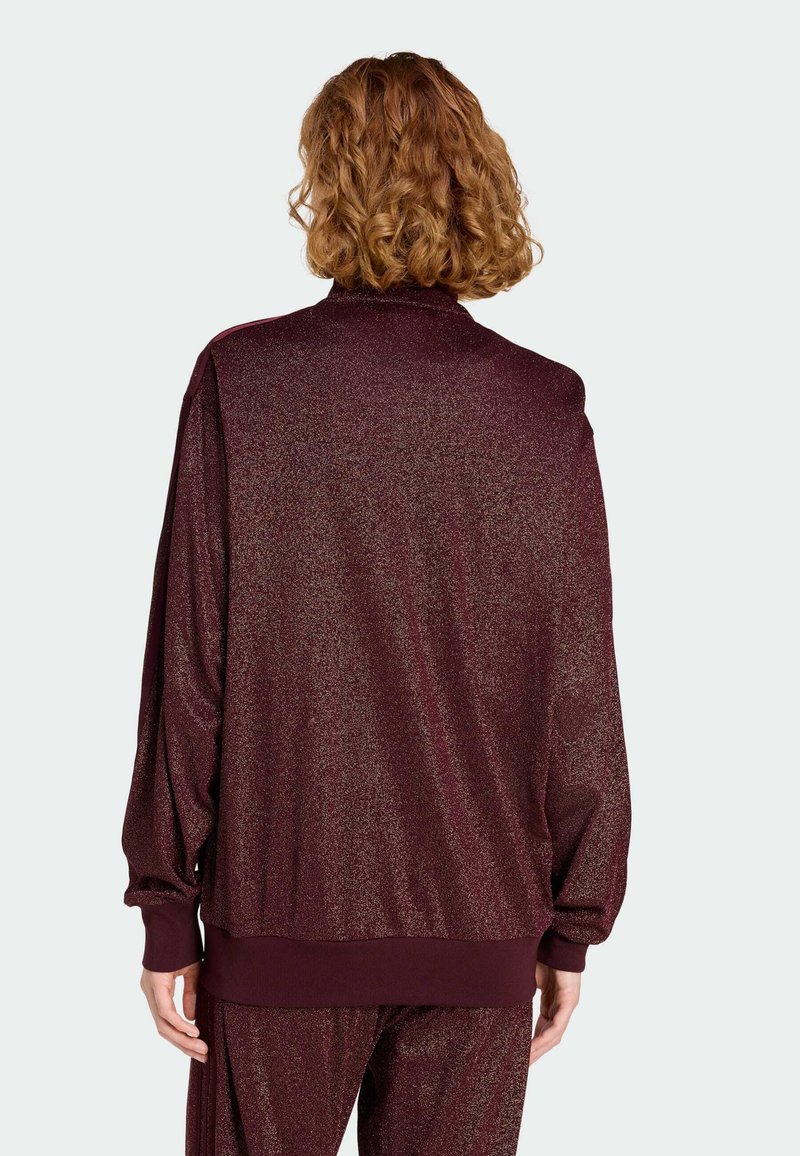 Bordeaux pullover jack met een glanzende textuur, relaxte pasvorm, lange mouwen en geribbelde manchetten en zoom. Minimalistisch ontwerp, geen zichtbare bevestigingsmiddelen.