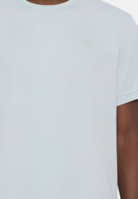 T-shirt azzurro chiaro a maniche corte realizzato in tessuto morbido, con un logo discreto sul petto. Collo a giro classico, design slim fit.