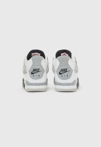 Biele tenisky Nike Air majú šedé akcenty, škvrnitú medzipodrážku, polstrovaný golier a charakteristické logo na päte.