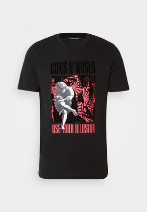 Camiseta de algodón negra con un gráfico audaz en rojo y blanco que dice "GUNS N' ROSES" y "USE YOUR ILLUSION", rodeado de un fondo con patrón.