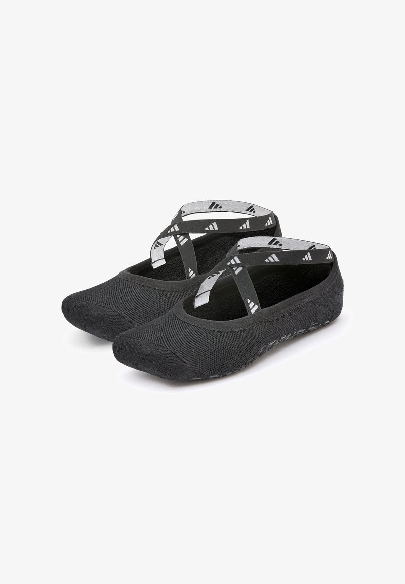 Black slip-on shoes with a textured finish, featuring crisscross elastic straps and a flexible sole. Designed for comfort and ease of wear.