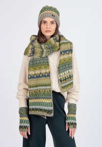 Chapeau tricoté, écharpe et gants sans doigts en vert, jaune et gris avec des motifs géométriques. Texture cozy, matériau en laine, design moderne.
