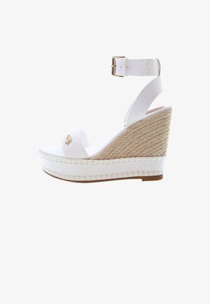 White wedge sandal with a fabric upper and a woven jute heel. Features a buckle strap and a small gold decorative accent.