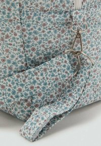 Borsa in tessuto con motivo floreale, caratterizzata da fiori azzurri e rosa su sfondo bianco, con dettagli in metallo argentato e tracolla.
