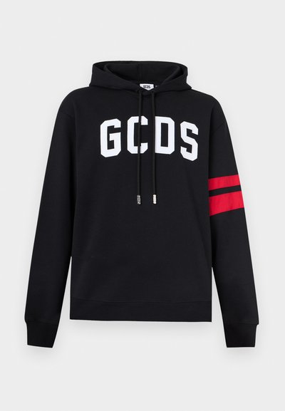 Svart hettegenser med hvite "GCDS"-bokstaver på brystet, røde og svarte striper på venstre erme, og svarte snorer med merketipper.