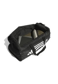 Bolsa de deporte negra con cremallera en la parte superior, con franjas blancas, asas resistentes y un interior espacioso que contiene una laptop y una botella de agua.