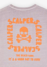 T-shirt in cotone viola chiaro con grafica arancione e design di un teschio. Il testo recita "SCALPERS THE BEACH GANG È UNA BELLA GIORNATA PER SURFARE."