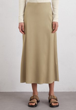 Beige satin midi skirt with a smooth texture, flared design, and a subtle sheen; paired with brown adjustable slide sandals.