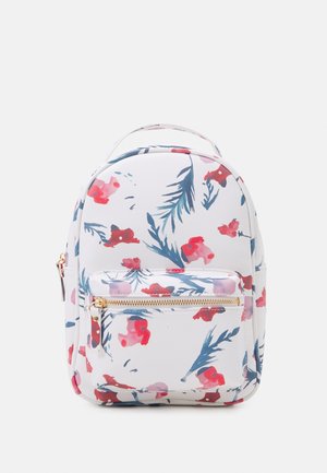 Witte rugzak met een bloemmotief met roze en blauwe bloemen, een voorvak met ritssluiting en gouden hardware accenten. Ronde vorm en stoffen materiaal.