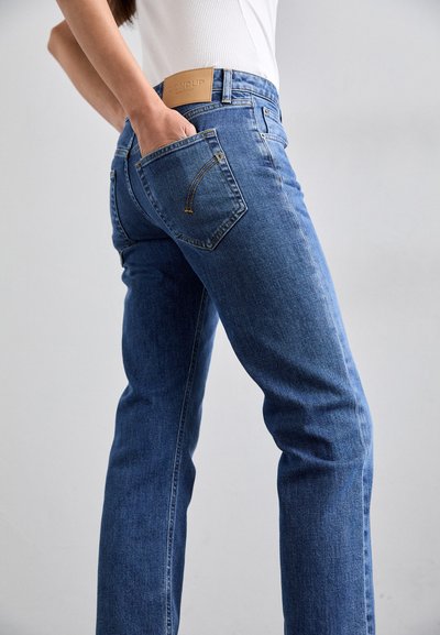 Jeans de denim azul con corte recto, que presentan una cintura alta, un parche de cuero marrón y un distintivo bordado en el bolsillo trasero.