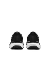 Des chaussures de sport noires avec une tige en mesh, une semelle intermédiaire blanche, une semelle extérieure en caoutchouc et des accents réfléchissants. Elles présentent un design épuré.