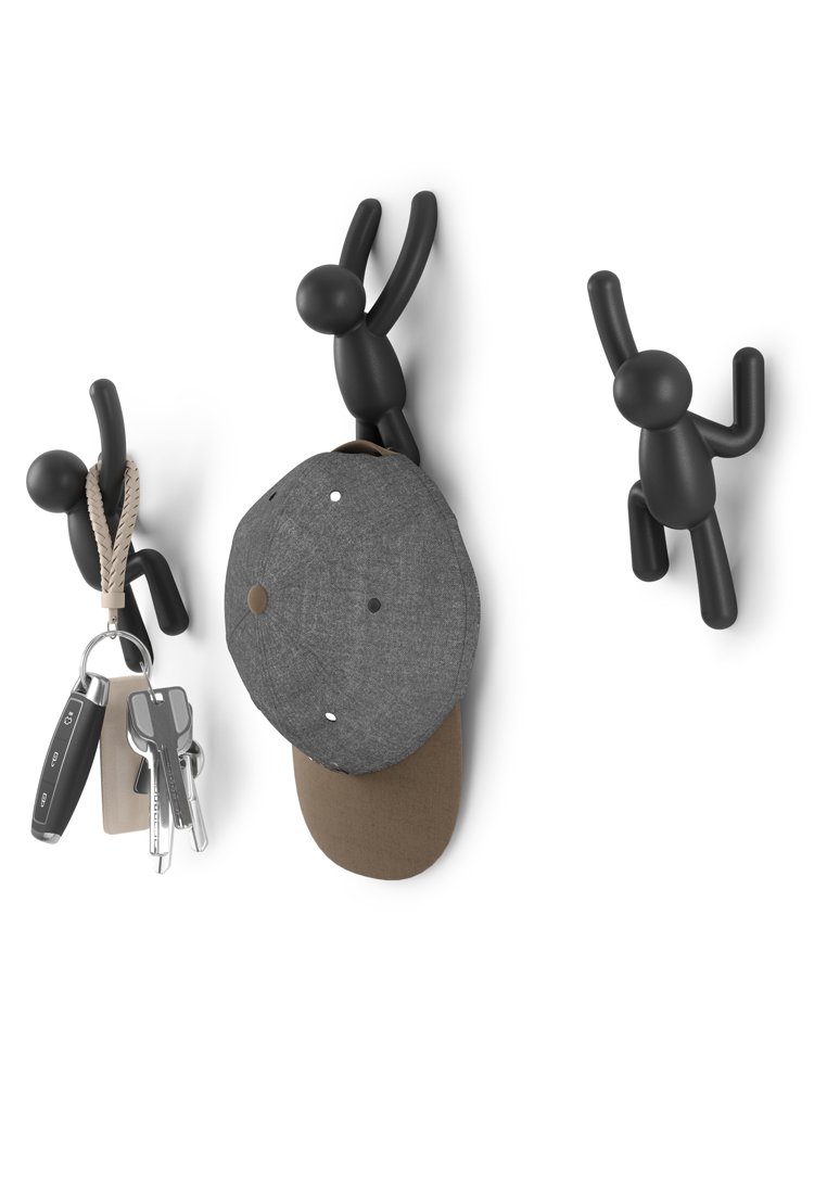Ganci da muro neri a forma di figure umane, che tengono un berretto grigio e delle chiavi. Realizzati in plastica con una finitura liscia. Design versatile.
