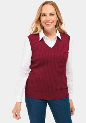 Bordeauxfarbener Strickwesten mit Kabelmuster, V-Ausschnitt und geripptem Saum, getragen über einem weißen Hemd mit Kragen.