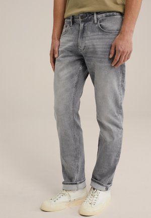 Gray denim jeans featuring a faded wash, straight-leg design, visible front pockets, and rolled cuffs; paired with white sneakers.