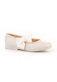 Zapato plano color blanco roto con punta redonda y gran lazo decorativo de tela en el lado exterior, forro interior suave visible.