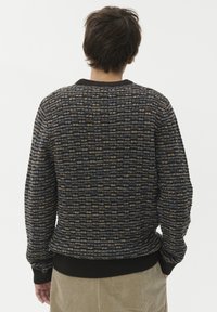 Zimska pulover iz pletenine z zanimivim vzorcem v mornarsko modri, zlati in modri barvi. Ima krojen ovratnik ter rebraste manšete in rob.