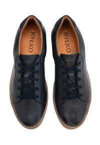 Mornarske usnjene superge imajo teksturirano zgornji del, okroglo konico, črne vezalke in svetlo rjavo gumijasto podplato. Notranjost ima svetlo rjavo oblazinjeno vložke.