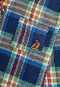 Karierte Hemd mit blauen, grünen, roten und braunen Farbtönen, einer Brusttasche und einem gestickten Segelboot-Logo. Hergestellt aus strukturiertem Stoff.