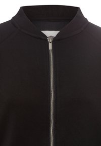 Schwarze Zip-Jacke mit geripptem Kragen, silbernem Reißverschluss und einer glatten Stofftextur. Das Design ist minimalistisch ohne sichtbare Muster.