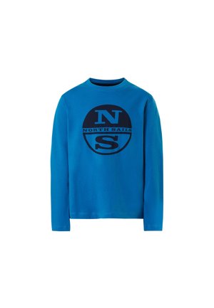 Camiseta de manga larga en algodón azul brillante, con un gran gráfico azul marino que incluye la letra "N" y el texto "NORTH SAILS". Cuello redondo sencillo, corte clásico.